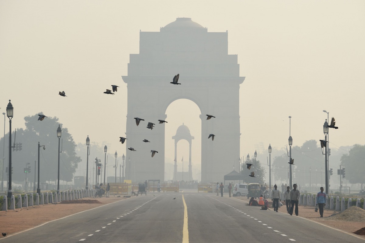 Indian pedestrians walk near the India Gate monument amid heavy smog in New Delhi (AFP file photo) 