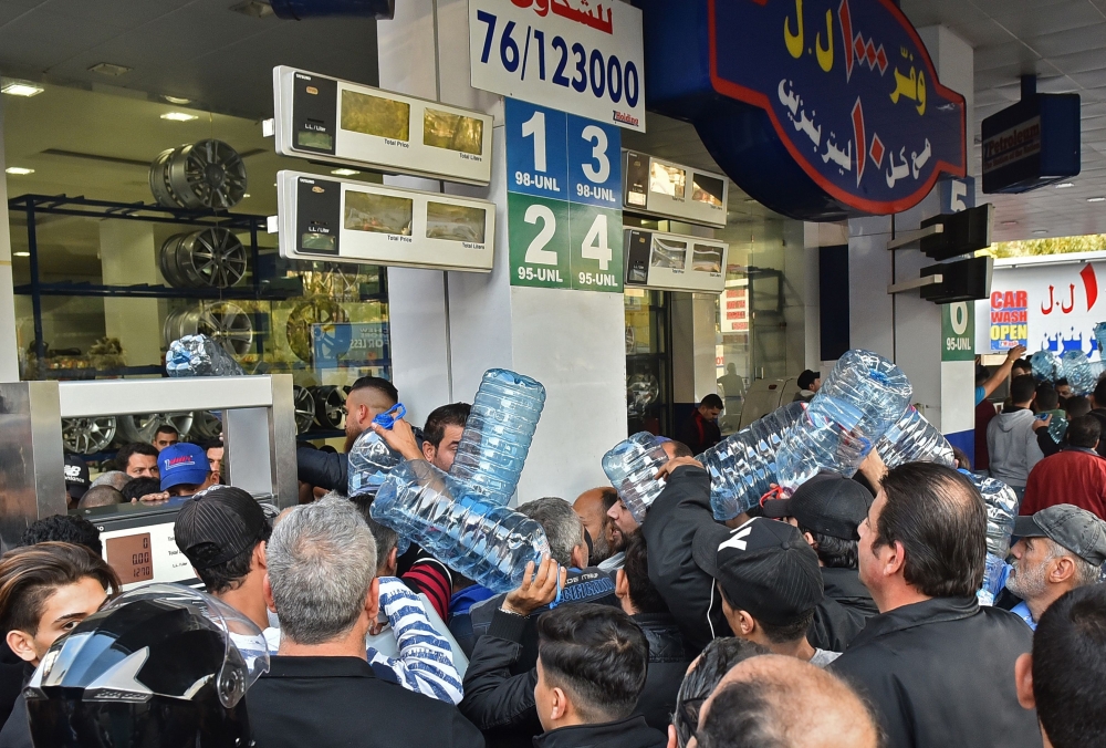 Lebanese people queue in front of a petrol station in Beirut's Cola district on November 29, 2019, following an open strike called for by the Syndicate of Fuel Station Owners.  AFP 
