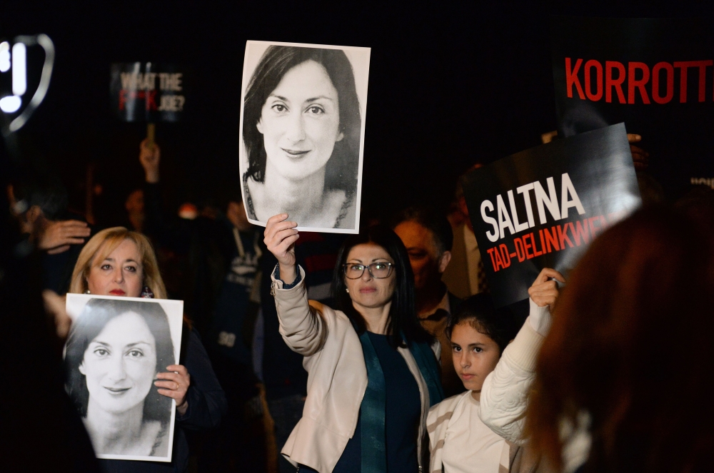 File photo: Protesters hold up placards and pictures of the late journalist Daphne Caruana Galizia as they gather outside the prime minister office in Valletta, Malta on November 20, 2019. AFP / Matthew Mirabelli