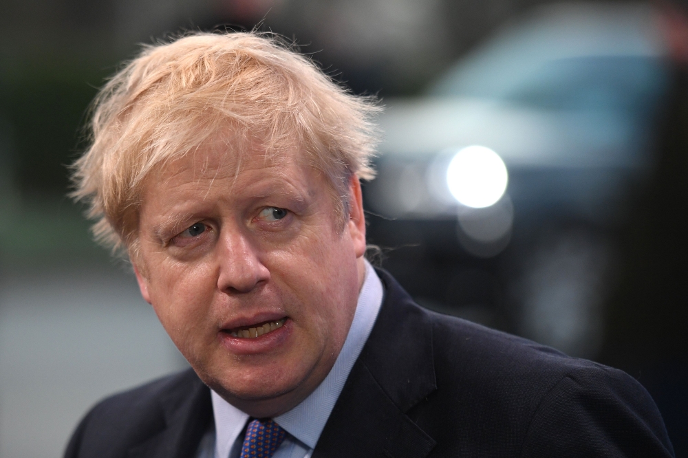 Britain's Prime Minister Boris Johnson speaks to the press on arrival at the NATO summit at the Grove hotel in Watford, northeast of London on December 4, 2019. / AFP / DANIEL LEAL-OLIVAS