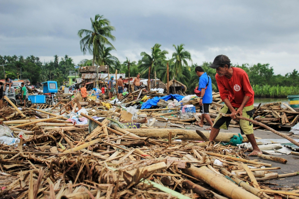 Residents gather debris from their destroyed houses after typhoon Kammuri hit the city of Sorsogon, south of of Manila on December 3, 2019. Typhoon Kammuri killed at least two people in the Philippines on December 3 as it tore roofs off houses and forced 