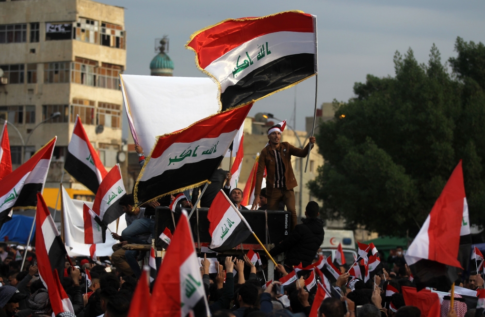 Iraqi demonstrators wave national flags as they take part in an anti-government demonstration in the capital Baghdad's Tahrir Square, on December 6, 2019. AFP / AHMAD AL-RUBAYE