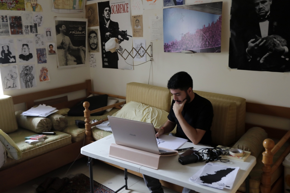 Lebanese cartoonist Mohamad Alameddine works at his studio in the capital Beirut on December 6, 2019. AFP / Joseph Eid 