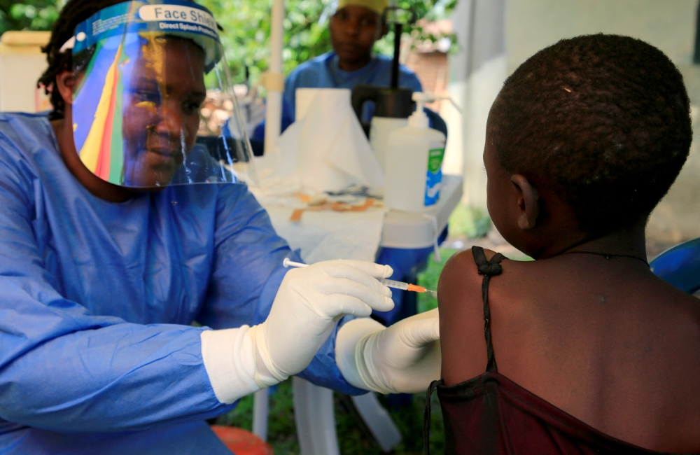 FILE PHOTO: A Ugandan health worker administers the Ebola vaccine to a child in Kirembo village, near the border with the Democratic Republic of Congo in Kasese district, Uganda, June 16, 2019. REUTERS/James Akena
