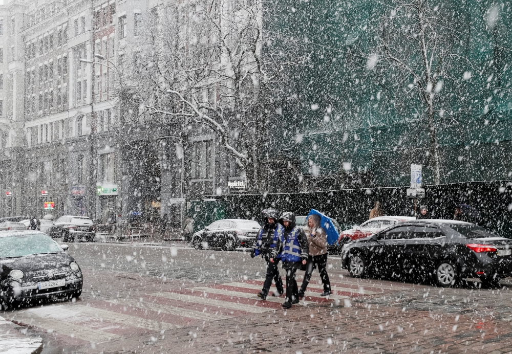 People cross a street amid a snow flurry in central Kiev, Ukraine, March 27, 2019. Reuters / Gleb Garanich
