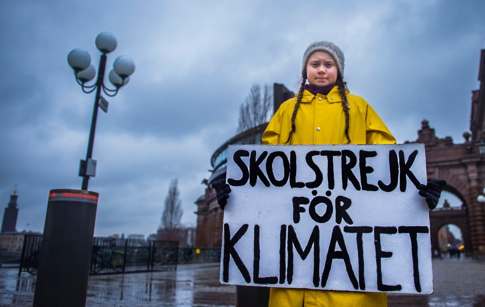 Greta Thunberg holds a placard reading ‘School strike for the climate’ outside the Swedish parliament in Stockholm, Nov 30, 2018. TT News Agency / Hanna Franzen / Reuters. 