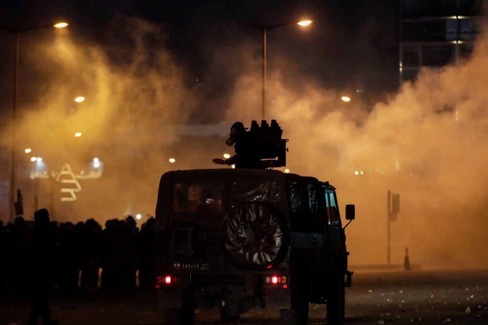 Lebanese riot police prepare to fire teargas canisters during clashes with anti-government demonstrators in the capital Beirut on December 14, 2019. / AFP / SERVICES AFP / ANWAR AMRO