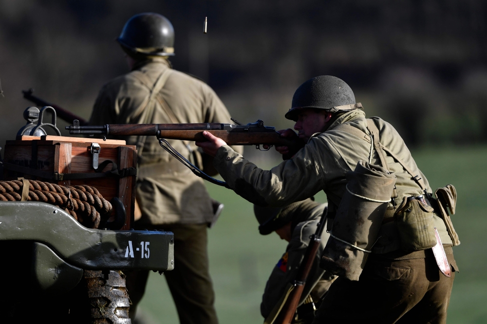 TOPSHOT - An actor wearing a WWII US uniform aims with his rifle as he takes part in a historical re-enactment of the Battle of the Ardennes as part of commemorations marking the 75th anniversary of the WWII battle, in Hardigny on December 15, 2019.  / AF