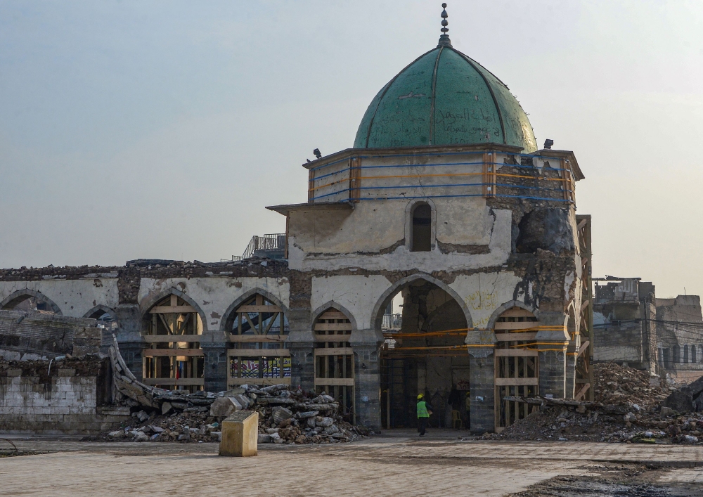 An Iraqi worker enters the Great Mosque of Al-Nuri during the complex's reconstruction in Mosul’s war-ravaged old town, on December 15, 2019. AFP / Zaid Al-Obeidi
 
