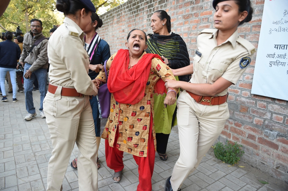 Gujarat Police officials detain a demonstrator during a peaceful protest against the Indian government's Citizenship Amendment Bill (CAB) outside Indian Institute of Management (IIM) in Ahmedabad on December 16, 2019.  AFP / Sam Panthaky 