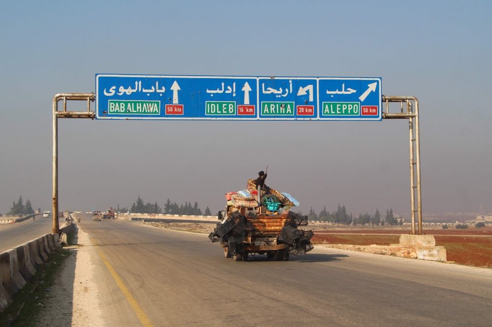 A Syrian boy sits atop personal effects in the back of a pick-up truck fleeing bombardment in the town of Saraqib, in the northwestern Idlib province, on December 21, 2019.  AFP / Ibrahim Yasouf 