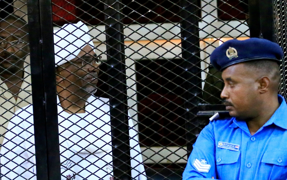 Sudan's former president Omar al-Bashir sits inside a cage during a hearing of the verdict. Sudan, December 14, 2019. REUTERS/Mohamed Nureldin Abdallah
