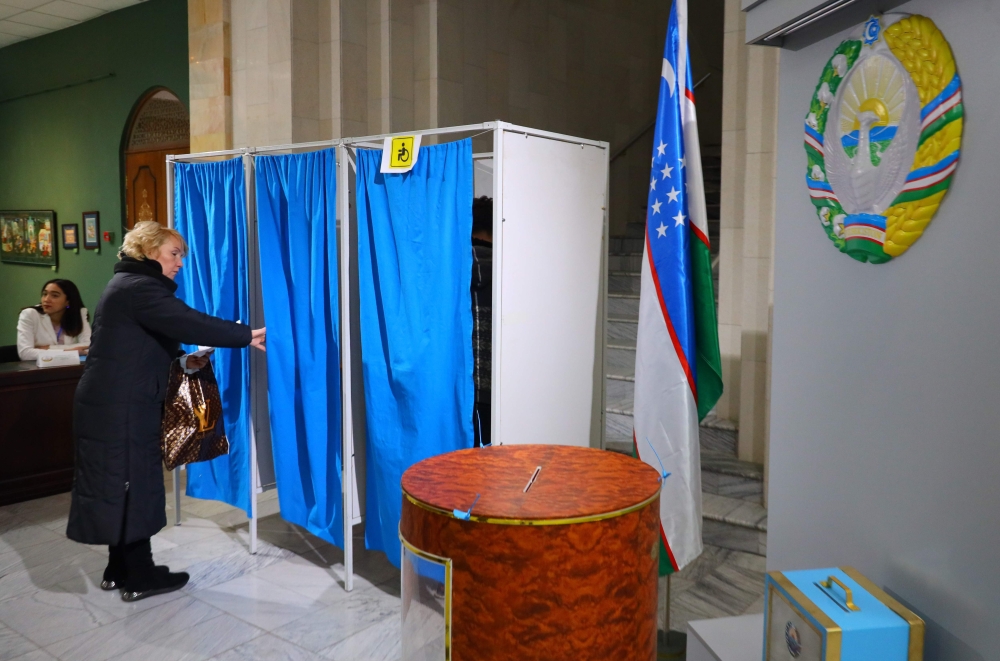 A woman goes in a polling booth before voting at a polling station in Tashkent on December 22, 2019. AFP / Yuri KORSUNTSEV