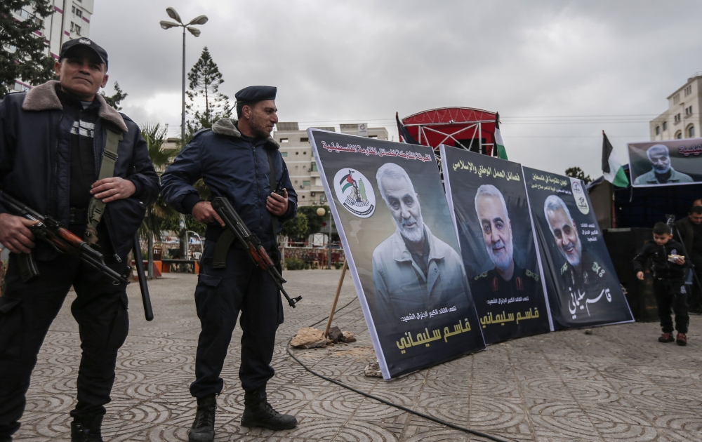 Hamas policemen in Gaza City stand guard during a mourning ceremony organised in honour of slain Iranian military commander Qasem Soleimani (portrait) killed in the Iraqi capital Baghdad in a US air strike a day earlier, on January 4, 2020. / AFP / MAHMUD