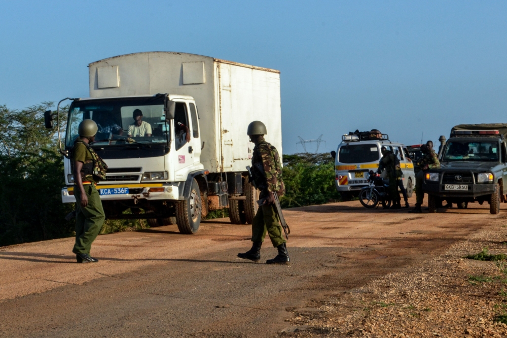 Kenyan police officers check vehicles on a road after a bus, travelling from the coastal region of Lamu to the town of Malindi, was ambushed by gunmen in Lamu county, southeast Kenya, on January 2, 2020.  AFP / STRINGER
