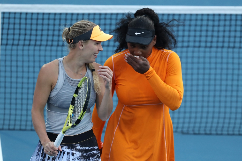 Serena Williams (R) of the US and Caroline Wozniacki of Denmark talk between points against Nao Hibino and Makoto Ninomiya of Japan during their women's doubles first round match during the Auckland Classic tennis tournament in Auckland on January 6, 2020
