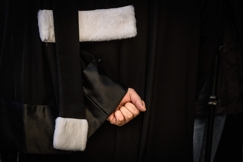 A lawyer closes his fist during a demonstration of lawyers against the French government's plan to overhaul the country's retirement system, on January 6, 2020 in Lyon, central eastern France. AFP / Jean-Philippe Ksiazek