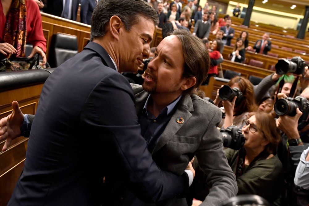 Spanish caretaker prime minister, socialist Pedro Sanchez, is congratulated by Spanish far-left Unidas Podemos coalition leader, Pablo Iglesias (R), after winning a parliamentary vote to elect a premier at the Spanish Congress (Las Cortes) in Madrid on Ja