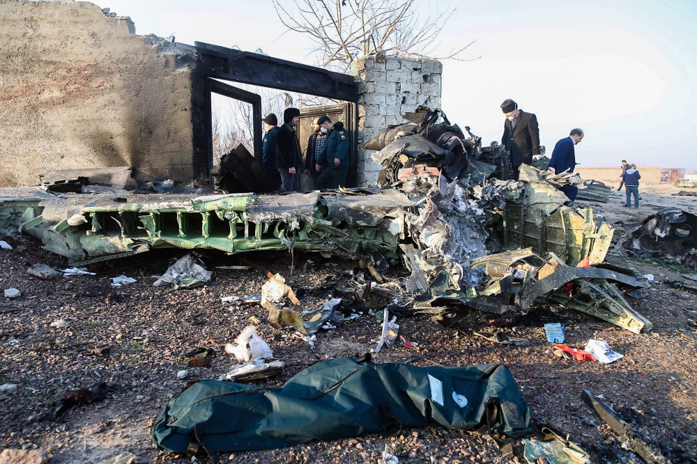 People stand near the wreckage after a Ukrainian plane carrying 176 passengers crashed near Imam Khomeini airport in Tehran on January 8, 2020. AFP / ISNA / ISNA / ROHHOLLAH VADATI