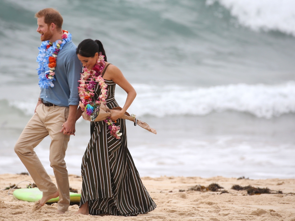British Prince Harry walks with his wife Meghan Duchess of Sussex as they meet the local community at Bondi Beach in Sydney on October 19, 2018. AFP / David Moir