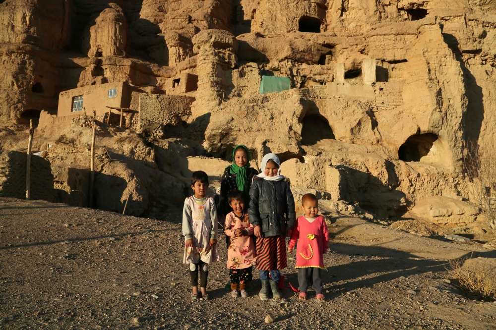 Hazara children in front of caves where they live with their family in Bamiyan on November 17, 2019. AFP / Mohammad Ali Shaida