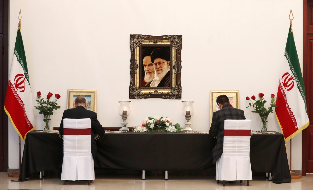 Men sign condolence books for the victims of the Ukraine International Airlines crash in Iran and for Iranian Major-General Qassem Soleimani, who was killed in an airstrike near Baghdad, at the Iranian embassy in Minsk, Belarus January 10, 2020. Reuters/V