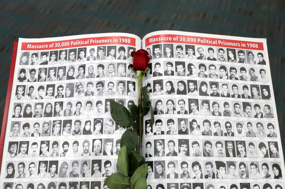 A rose rests on a page featuring photographs of people who have died in Iran as Iranian Americans from across California converge in Los Angeles to participate in the California Convention for a Free Iran and to express support for nationwide protests in