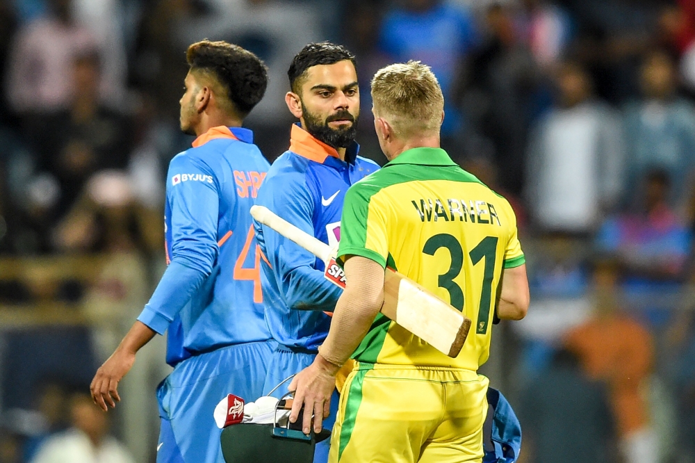 India's Virat Kohli (L) greets Australia's David Warner after the Australian team won the first one day international (ODI) cricket match of a three-match series between India and Australia at the Wankhede Stadium in Mumbai on January 14, 2020.  AFP / Pun