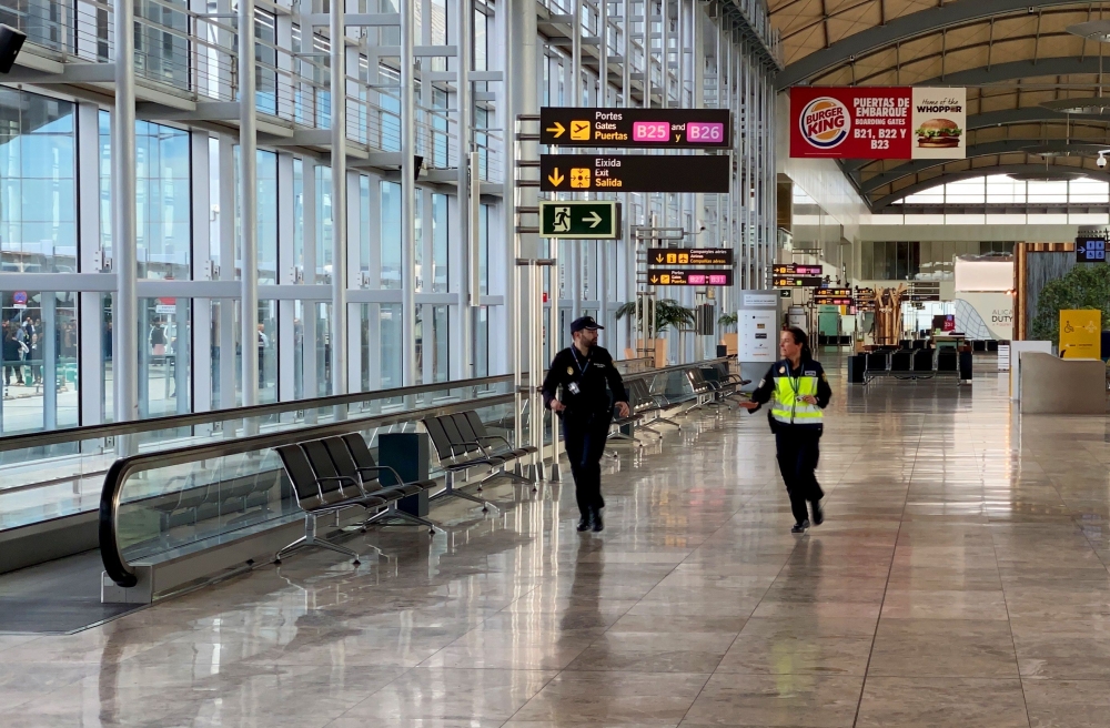 Spanish policemen walk at Alicante-Elche airport on January 15, 2020, in Alicante after a fire erupted in the terminal. / AFP / Daniel LEAL-OLIVAS