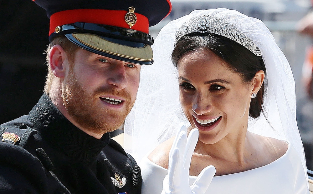 Prince Harry, his wife Meghan, Duchess of Sussex wave from the Ascot Landau Carriage during their wedding procession on the Long Walk, May 19, 2018. AFP pool / Aaron Chown