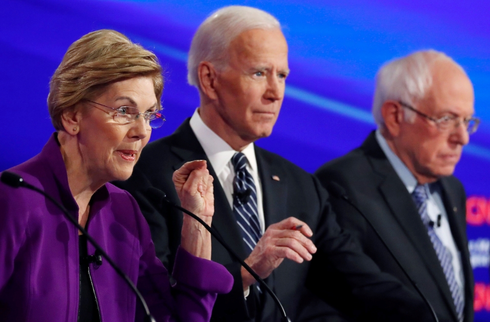 Elizabeth Warren speaks with Joe Biden and Bernie Sanders listening at the seventh Democratic 2020 presidential debate at Drake University in Des Moines, Iowa, US, January 14, 2020. Reuters/Shannon Stapleton