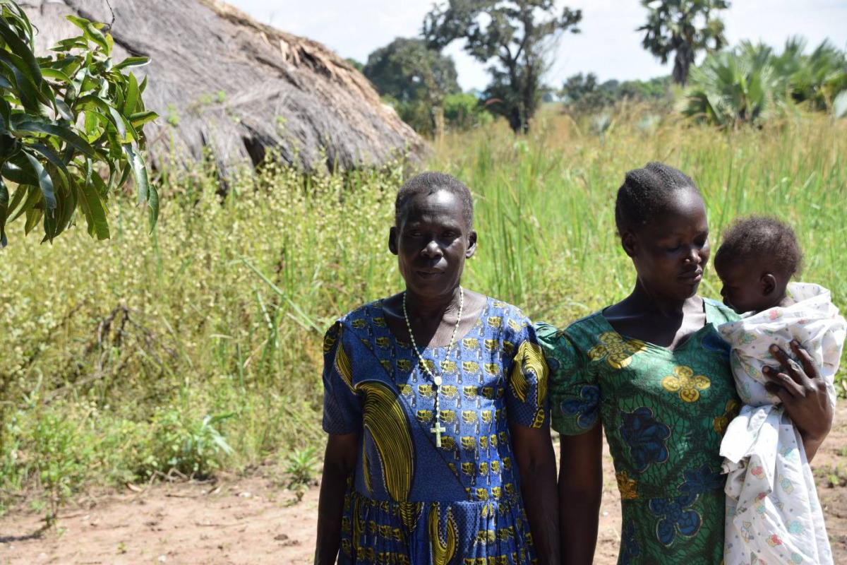 Pyerina Adong Otto (left) and family at her home in Awach, Uganda, December 5, 2019. Thomson Reuters Foundation/Liam Taylor
