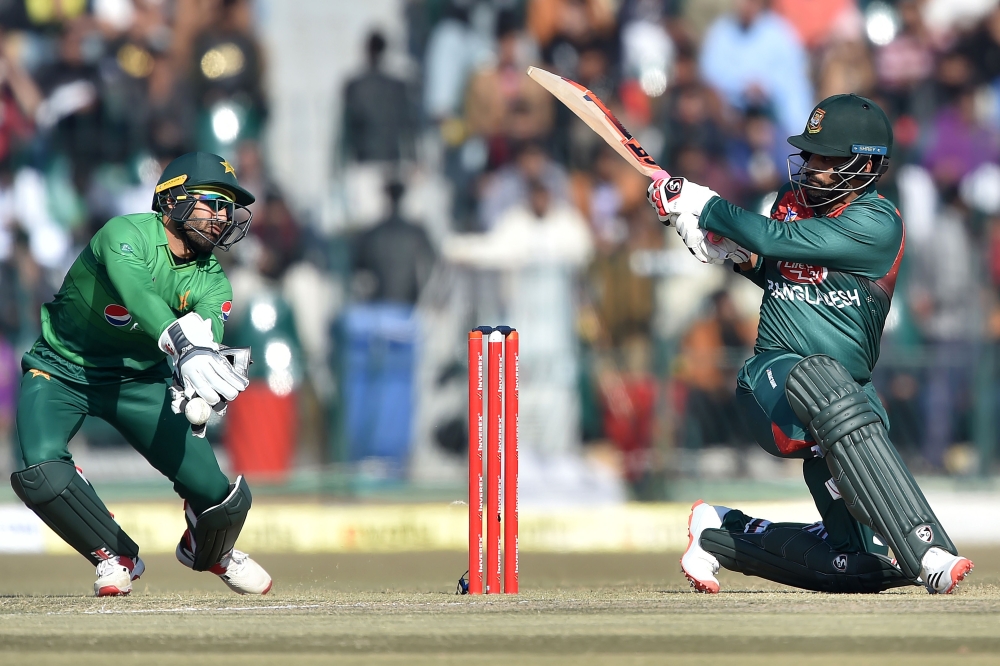 :Bangladesh's Tamim Iqbal (R) plays a shot as Pakistan's wicketkeeper Mohammad Rizwan tries to stop the ball during the first T20 international cricket match of a three-match series between Pakistan and Bangladesh at Gaddafi Cricket Stadium in Lahore on J