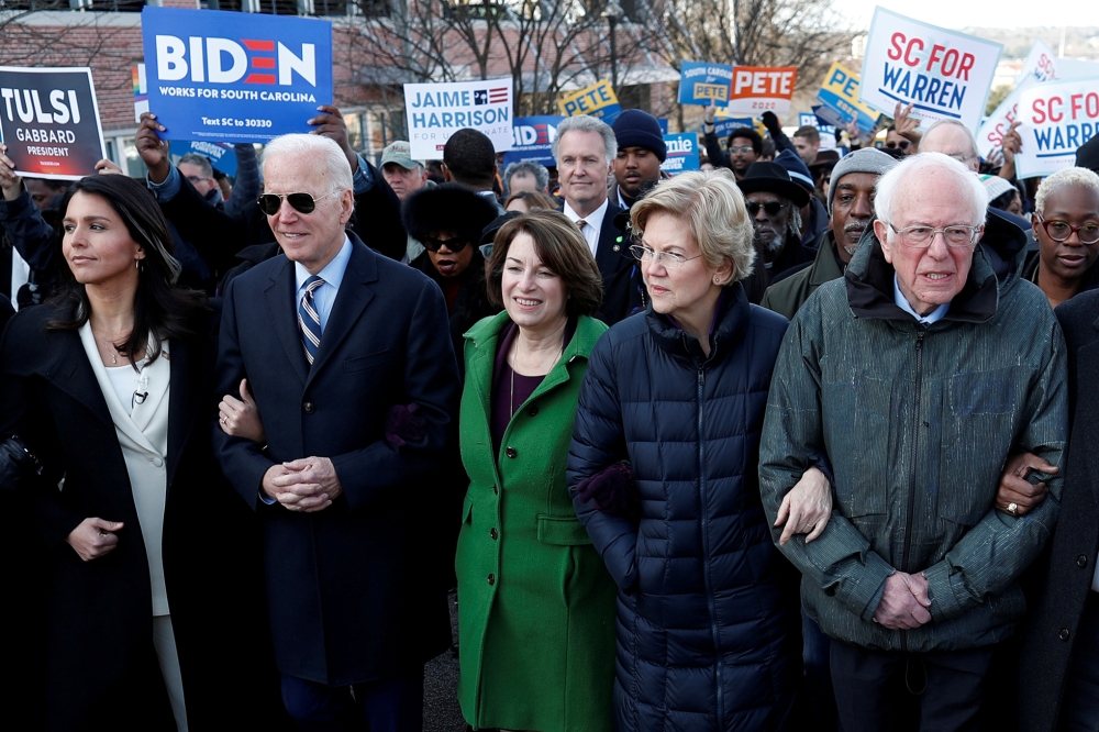 FILE PHOTO: Tulsi Gabbard, Joe Biden, Amy Klobuchar, Elizabeth Warren and Bernie Sanders, walk arm-in-arm with during the MLK Day Parade in Columbia, January 20, 2020. Reuters / Randall Hill