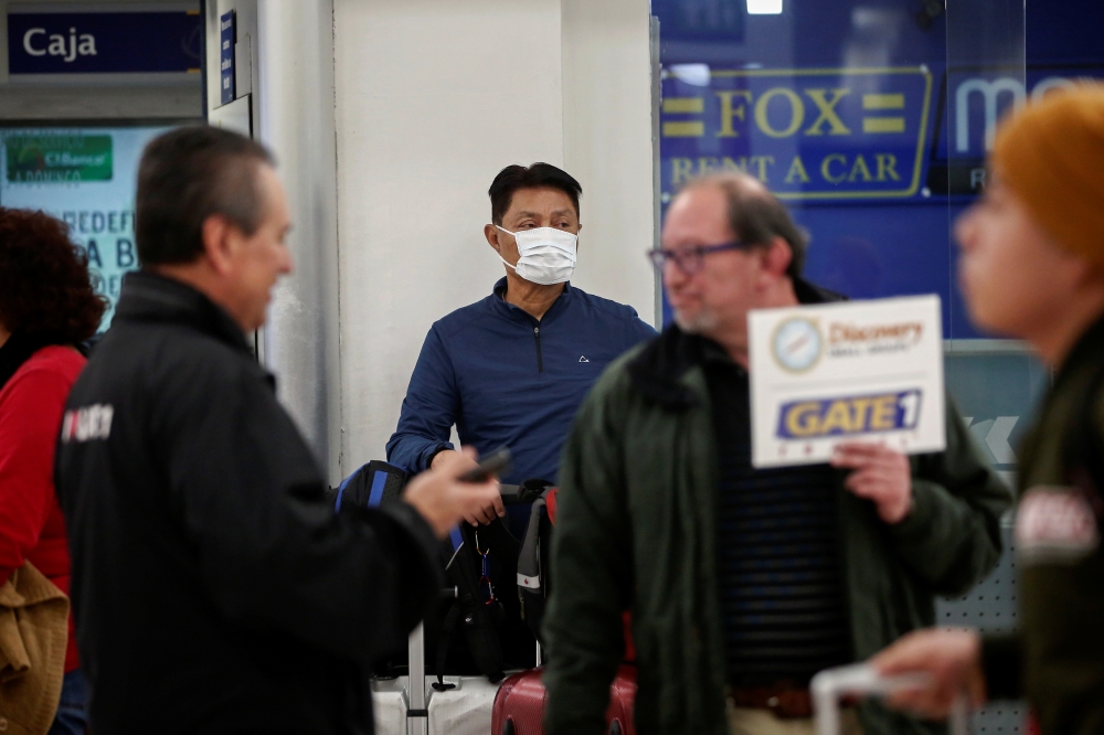 A traveler wears a surgical mask as a preventive measure in light of the coronavirus outbreak in China, after landing at Benito Juarez international airport in Mexico City, Mexico January 24, 2020. Reuters/Carlos Jasso 
