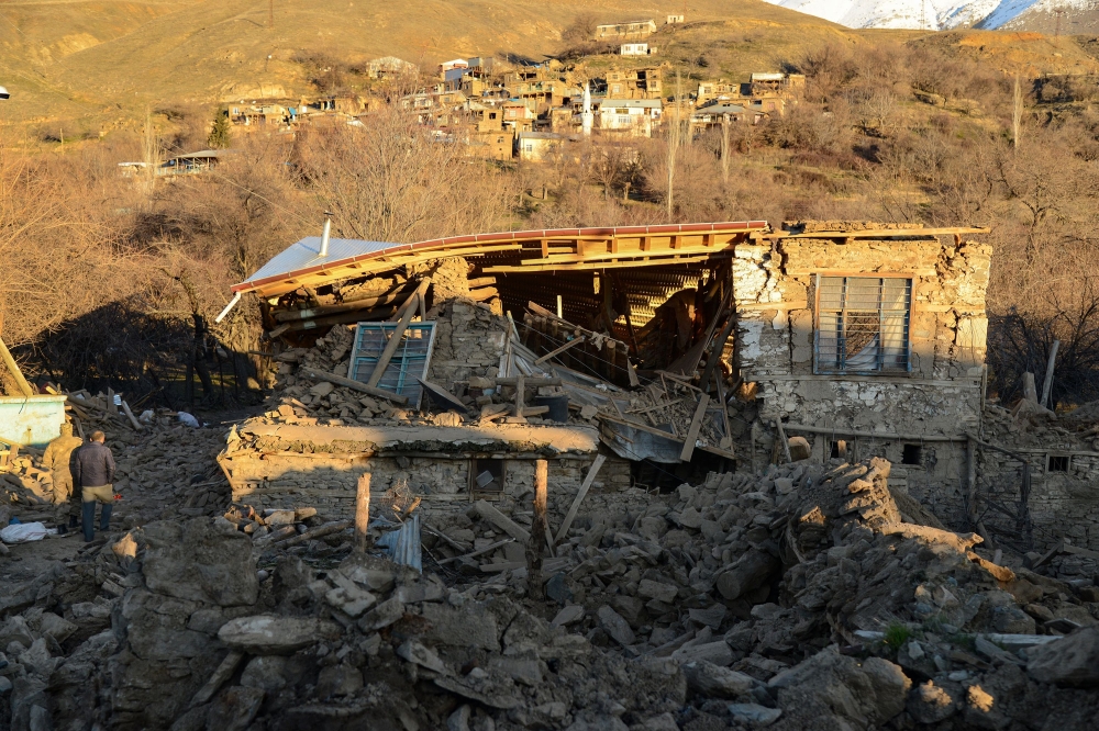 A villager walks by a collapsed house after an earthquake in Sivrice near Elazig, Eastern Turkey, on January 25, 2020. AFP / Ilyas AKENGIN