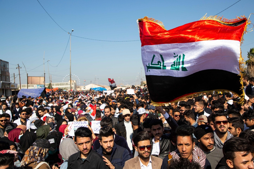 Iraqi demonstrators wave the national flag during an anti-government rally in the southern city of Basra on January 26, 2020. AFP / Hussein FALEH