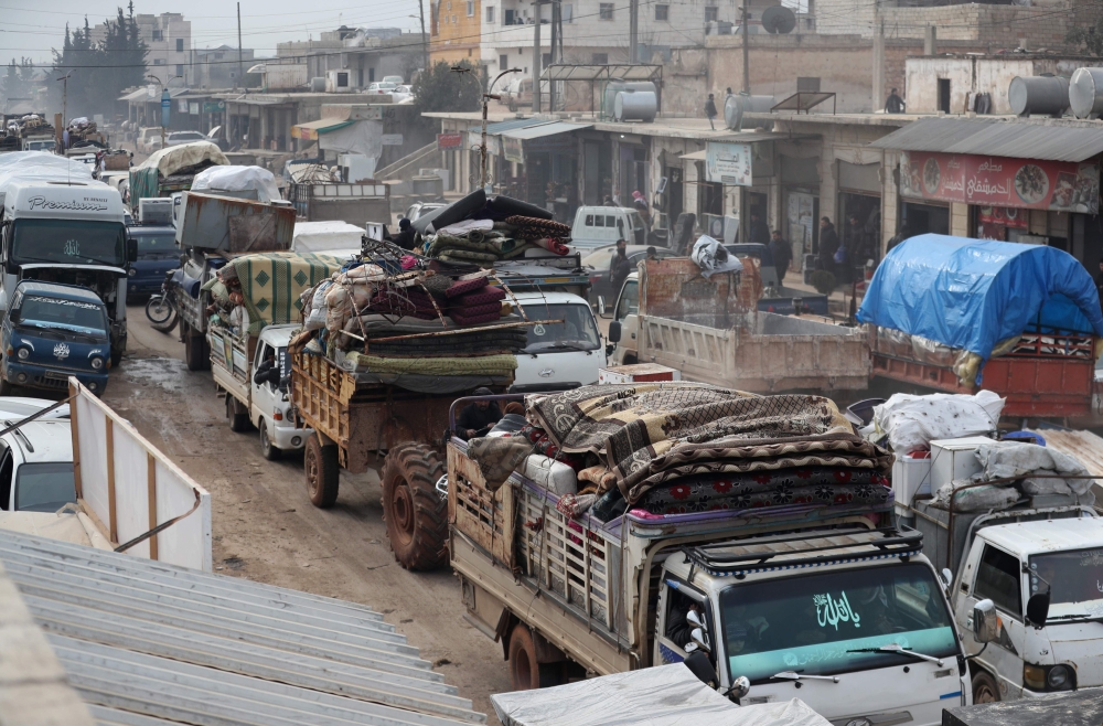 A convoy of trucks transporting the families and belongings of displaced Syrians drives through Hazano in the northern countryside of Idlib, after hundreds of people fled on January 28, 2020 its southern countryside towards areas further north near the bo