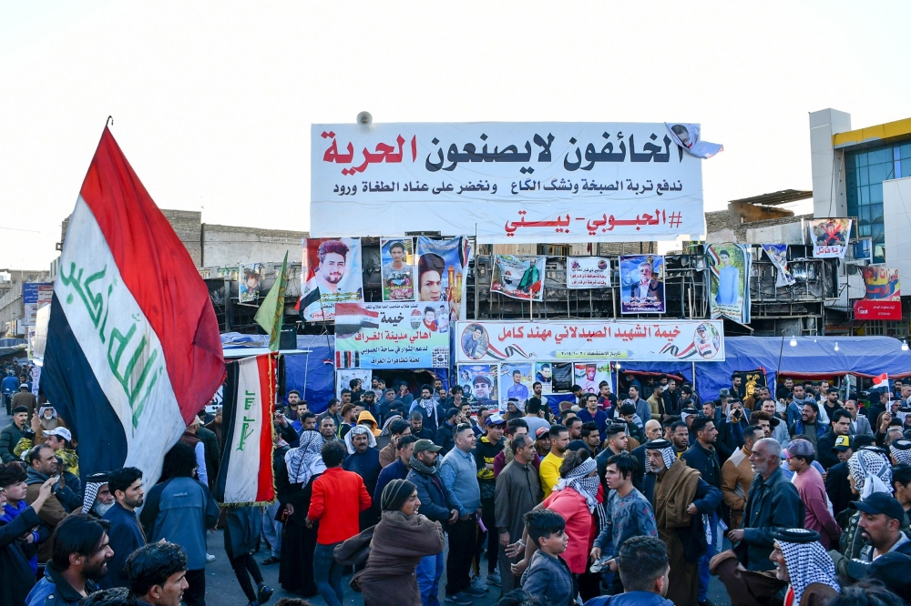 Iraq's wave the national flag during a gathering, rejecting the nomination of Mohammad Allawi as premier, in the city of Nasiriyah in Iraq's southern Dhi Qar province on February 2, 2020. AFP 