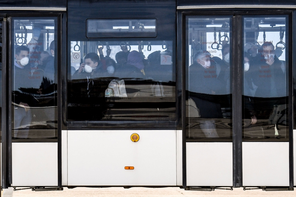 Italian citizens repatriated from the coronavirus hot-zone of Wuhan are transfered by bus after landing at the Mario De Bernardi military airport in Pratica di Mare, south of Rome, on February 3, 2020 prior to be placed in quarantine at the nearby Cecchig