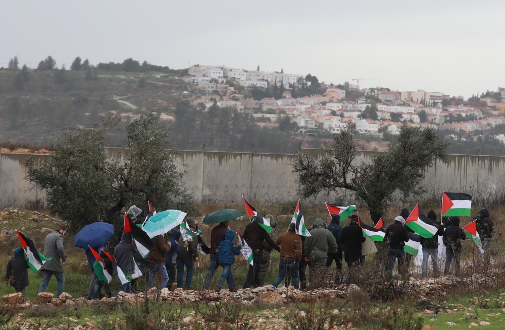 Palestinian demonstrators gather at the separation wall during a protest against US President Donald Trump’s Middle East plan near at Bil'in town in Ramallah, West Bank on February 07, 2020. (Issam Rimawi / Anadolu Agency)
 
