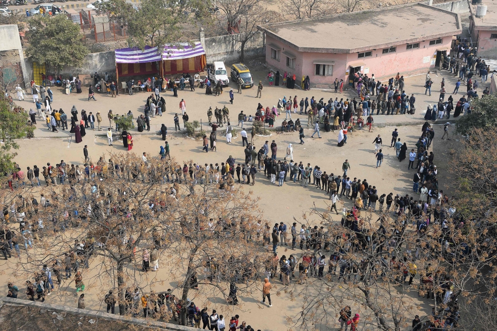 People queue at a polling station to cast their votes during the Legislative Assembly elections in New Delhi on February 8, 2020. / AFP / Sajjad HUSSAIN