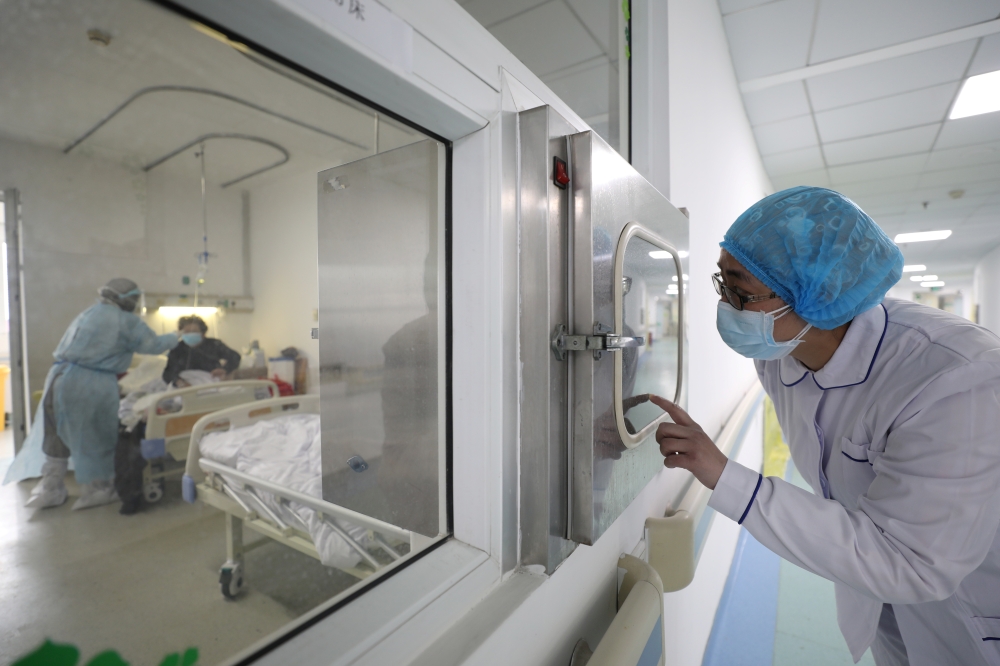 FILE PHOTO: A medical worker calls his colleague inside an isolated ward at Jinyintan Hospital in Wuhan, the epicentre of the novel coronavirus outbreak, in Hubei province, China February 13, 2020. 