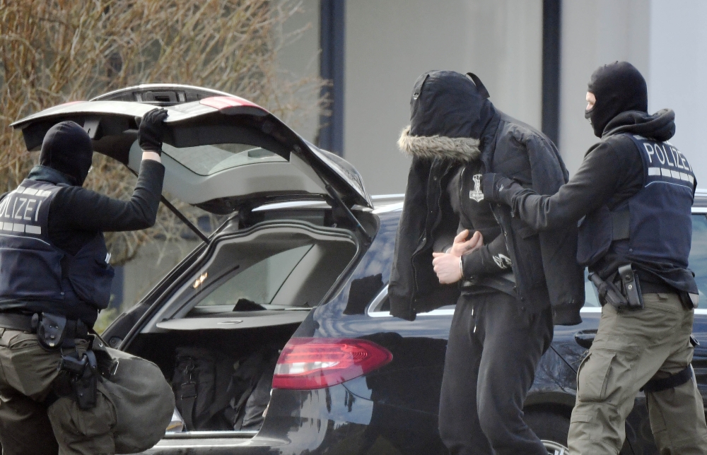 Picture shows police officers bringing a man believed to be one of the twelve men arrested a day earlier in a nationwide probe into an extreme-right at the Federal Supreme Court (Bundesgerichtshof) in Karlsruhe, southern Germany on February 15, 2020. Germ