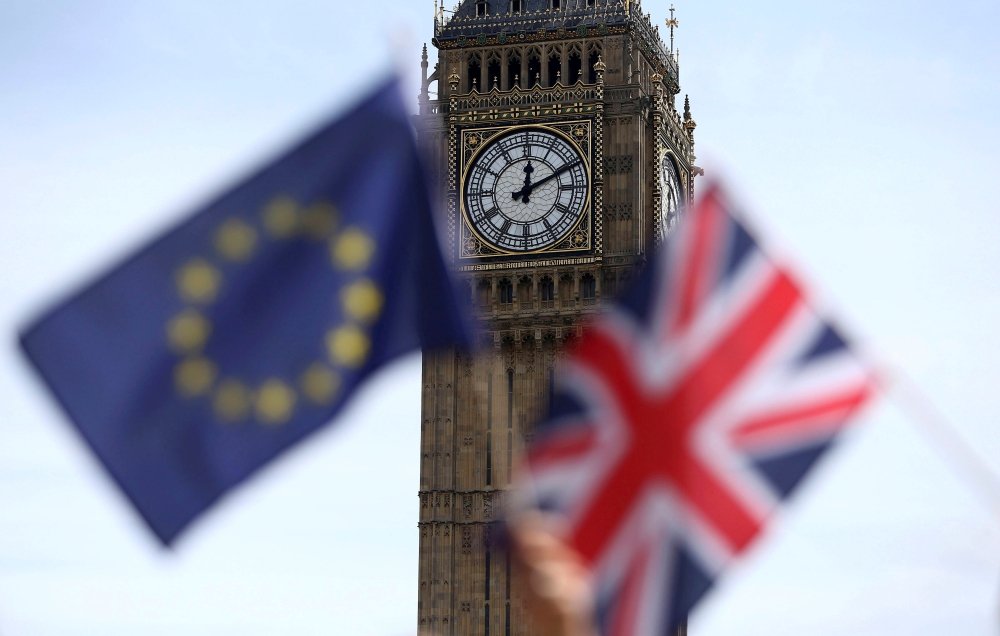 FILE PHOTO: Participants hold a British Union flag and an EU flag during a pro-EU referendum event at Parliament Square in London, Britain June 19, 2016. REUTERS/Neil Hall/File Photo