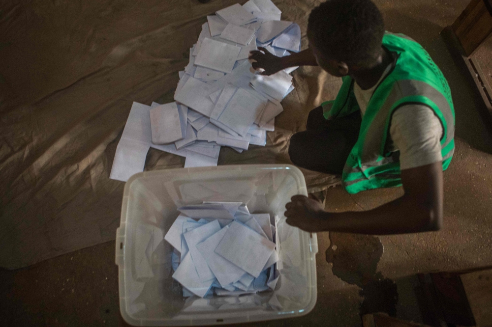 A polling station official counts the marked ballot papers at a polling station in Lome on February 22, 2020 during the first round of Togo presidential vote. AFP / YANICK FOLLY
