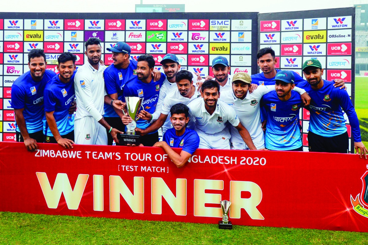 Bangladeshi cricketers pose for photos with the trophy following a presentation ceremony after winning the test match between Bangladesh and Zimbabwe during the fourth day at the Sher-e-Bangla National Cricket Stadium in Dhaka on February 25, 2020. AFP / 