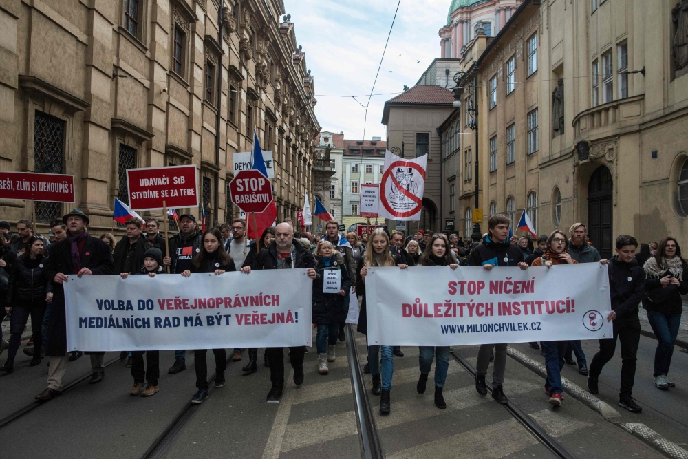 Protesters hold banners reading 