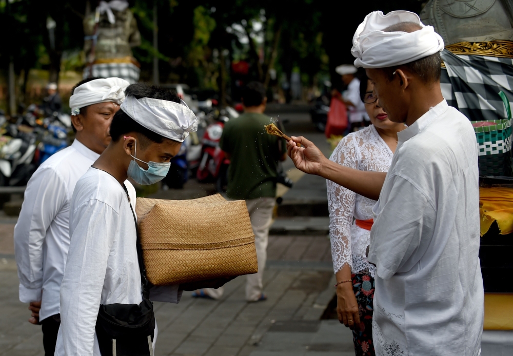 This picture taken on February 19, 2020 shows Balinese people gathering for a prayer event during the Galungan holiday at Jagatnata temple in Denpasar, Indonesia's resort island of Bali.  AFP / SONNY TUMBELAKA 