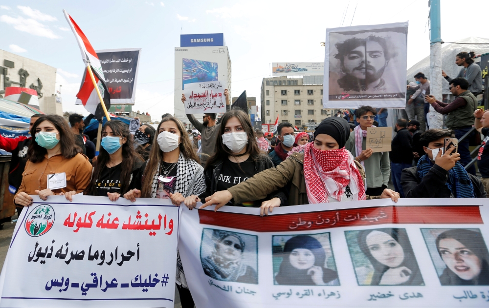 University students girls carry pictures of demonstrators who were killed during ongoing anti-government protests in Baghdad, Iraq March 1, 2020. Reuters/Wissam Al-Okaili